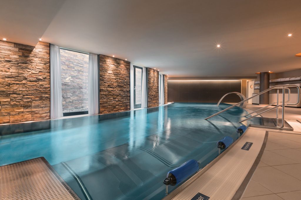 Eleganter SPA-Bereich mit Pool und seinen integrierten ergonomischen Sprudelliegen [Quelle: INFINITY MUNICH]